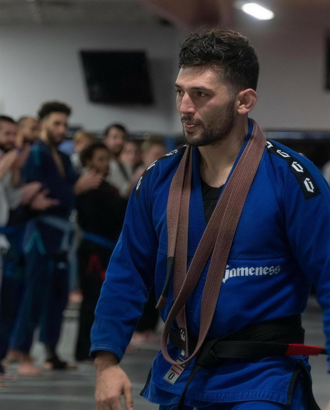 Coach Sean Doenias on the mat in a blue gi after class