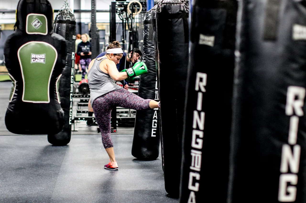 A student working a kick on the heavy bag