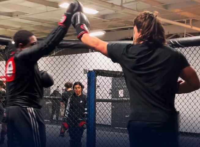 Training partners touching gloves in the cage