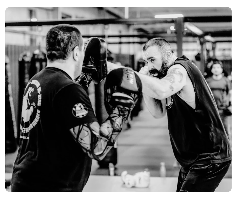 A boxer working punches on focus mitts
