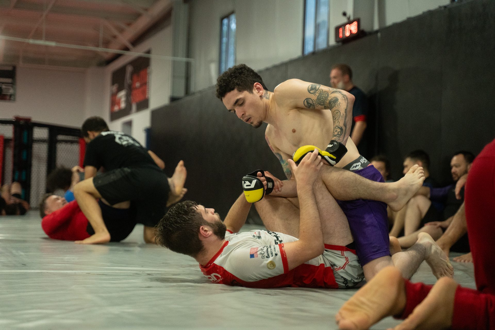 Live MMA-glove sparring round at TRITAC under coach supervision