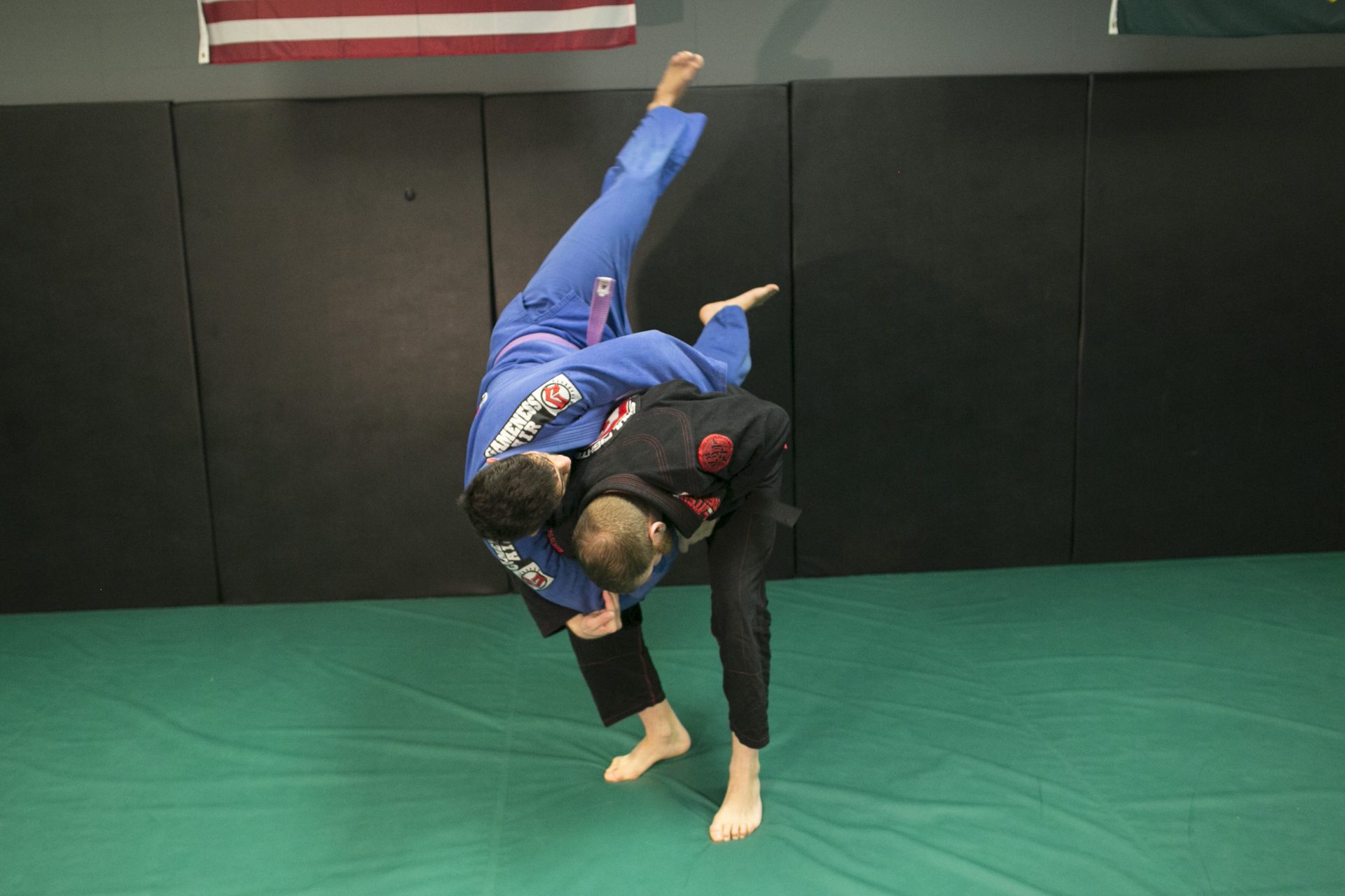 A traditional jujitsu throw mid-air during gi training