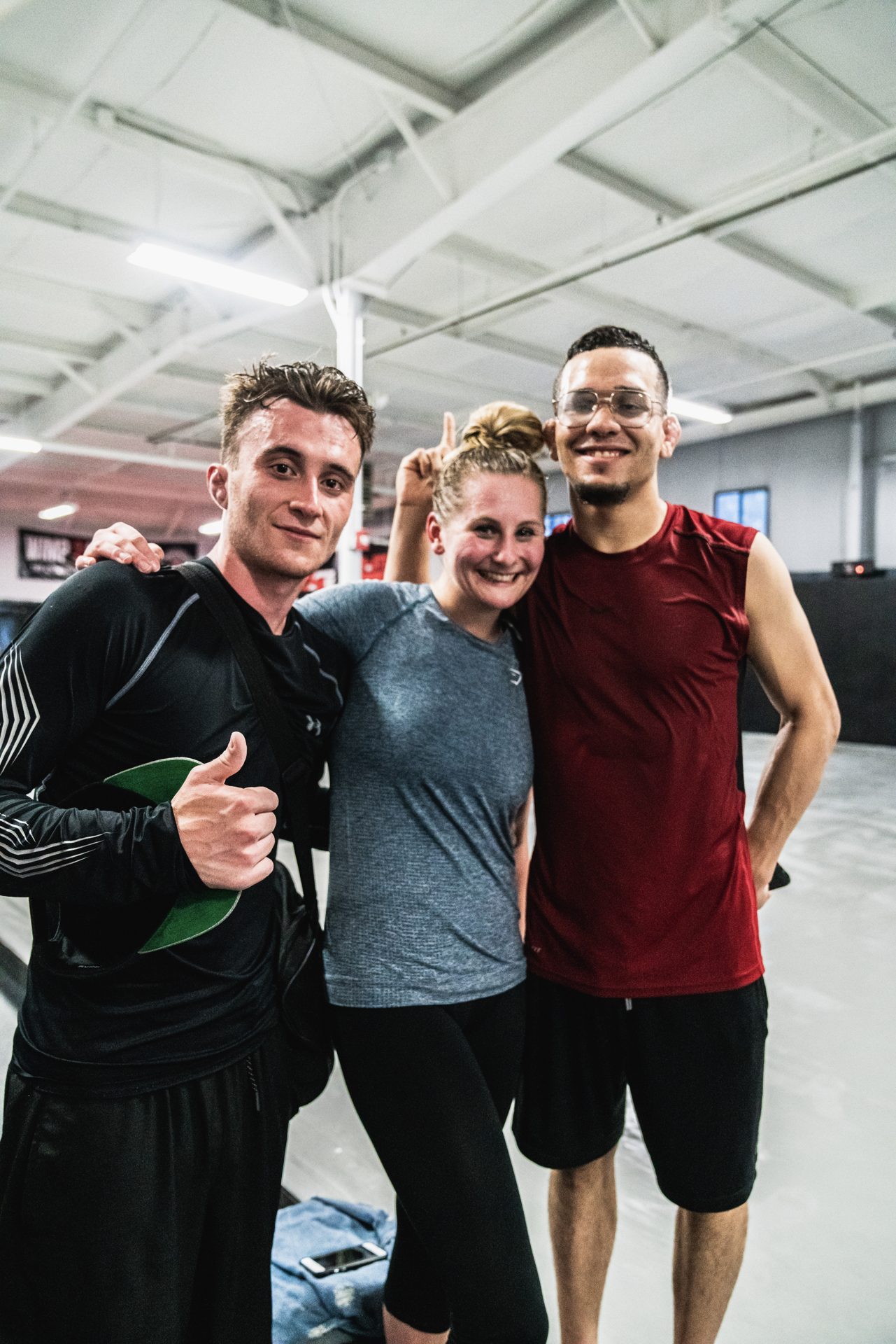 Three training partners, arms around shoulders, after a session