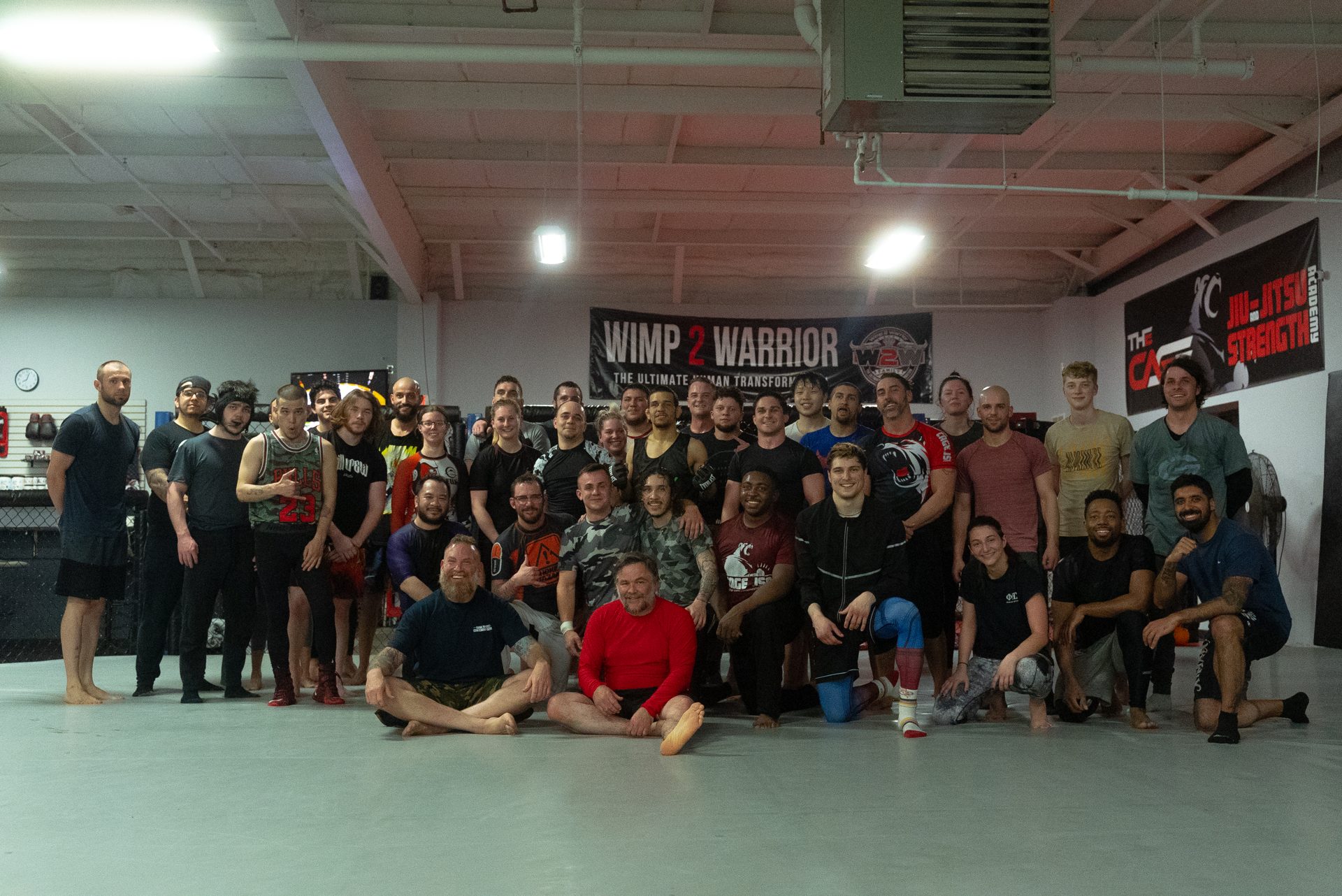 Large group photo of TRITAC members and coaches on the training floor