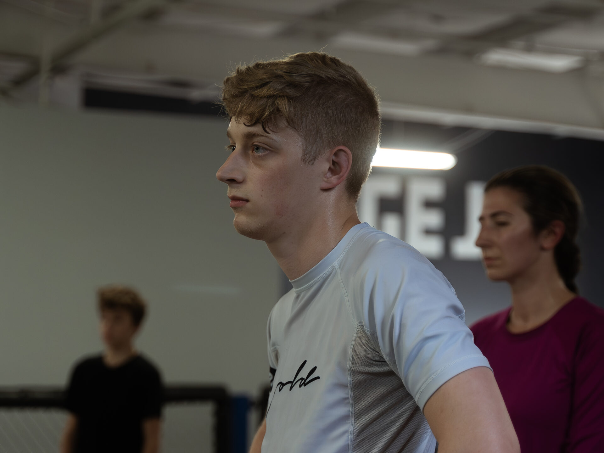 A member in profile on the training floor, the room out of focus behind him