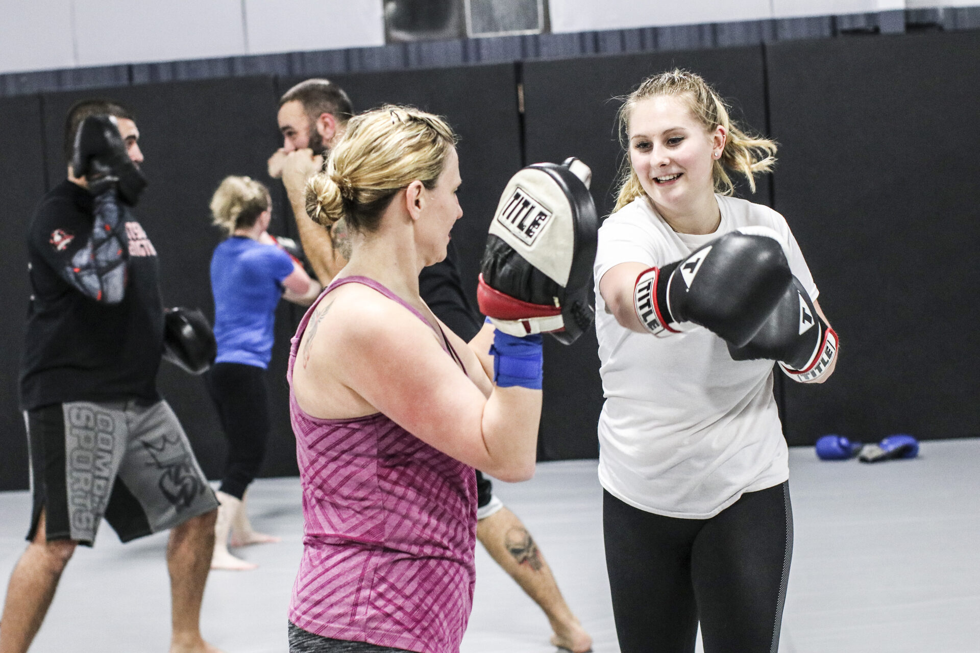A full class working in pairs on mitts and gloves