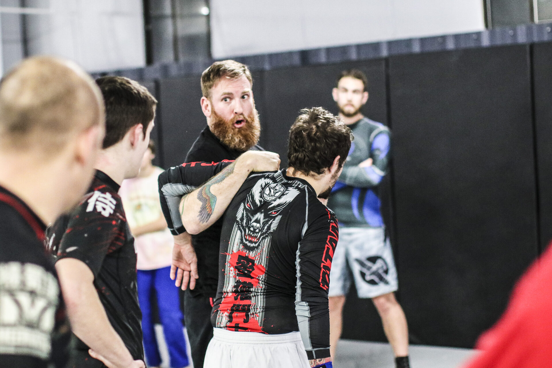 Matt Bryers correcting a student's position mid-class while the rest of the room watches