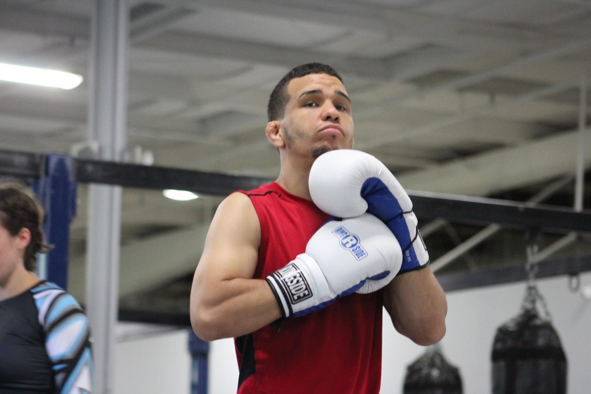 A man in training gloves working alone in the heavy bag row