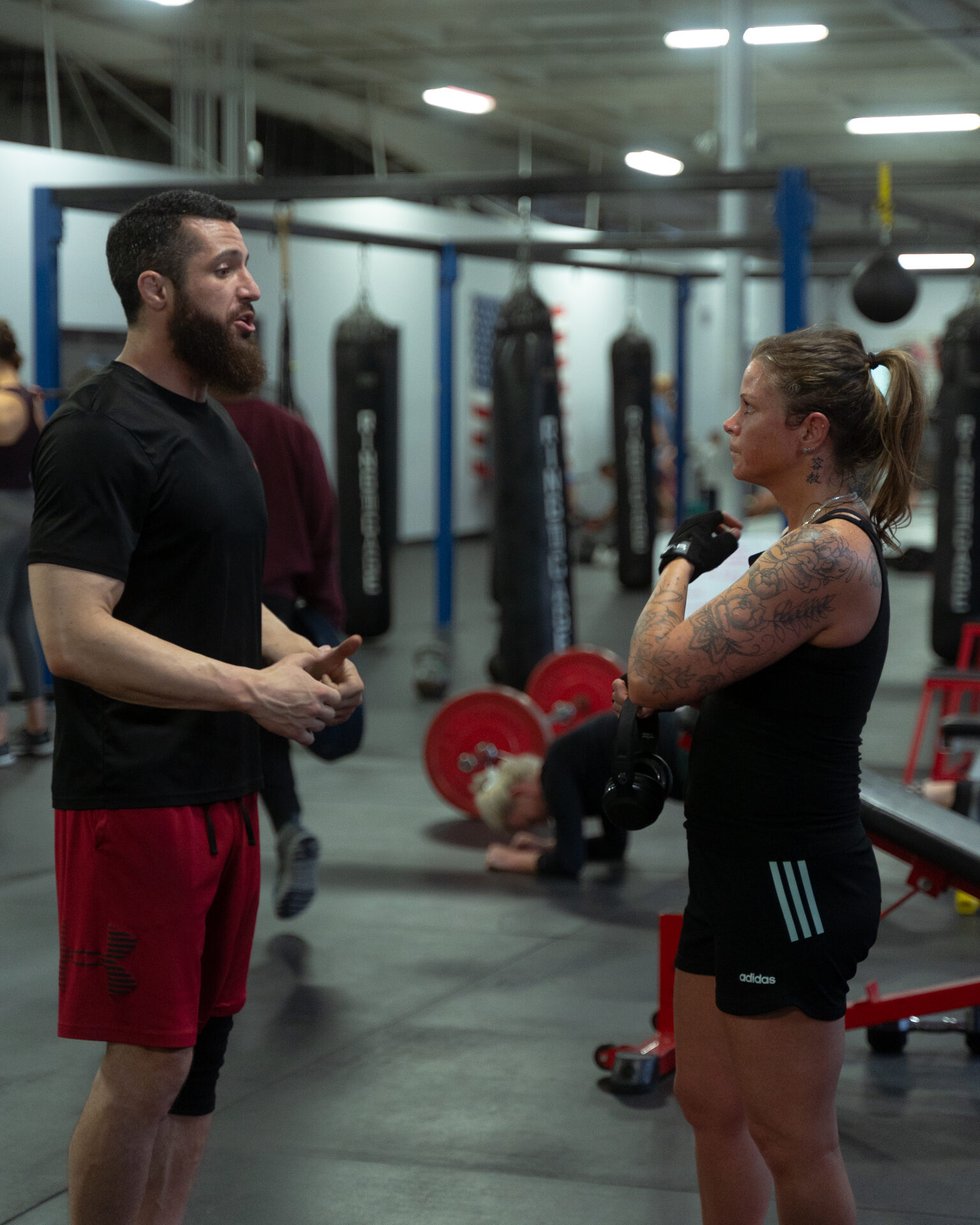 One coach working one athlete through a single lift, nobody else on the floor