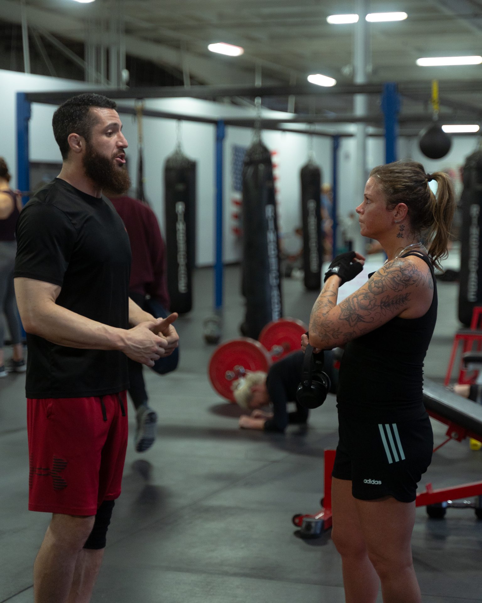 A coach in conversation with a member on the training floor