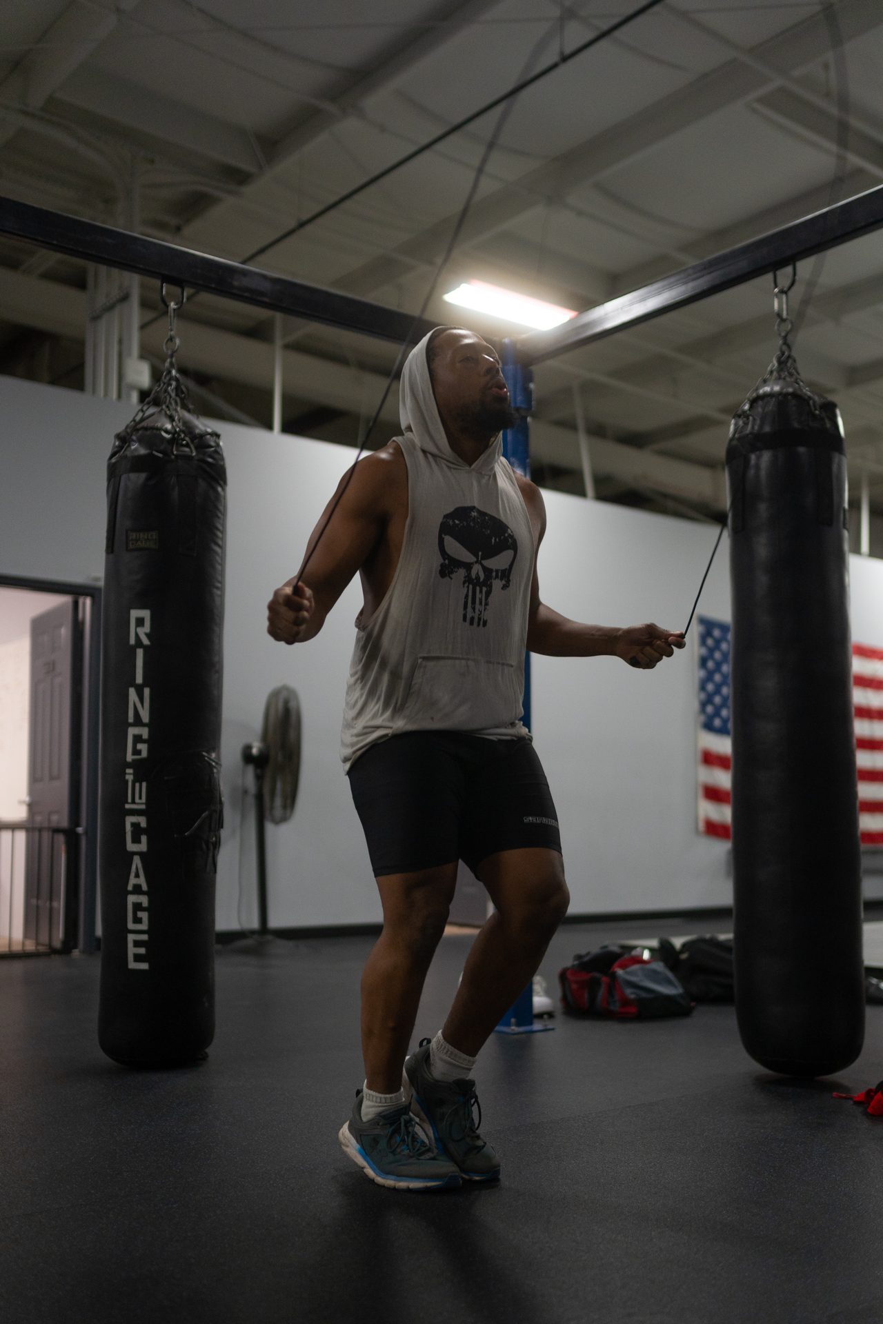 An athlete jumping rope between heavy bags before class